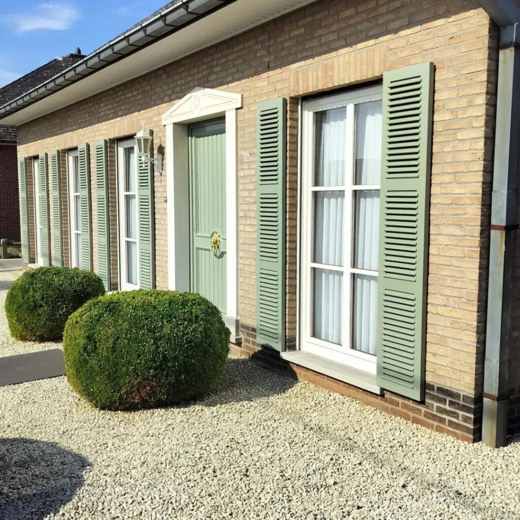 Beige villa met groengrijs geschilderde luiken en witte ramen
