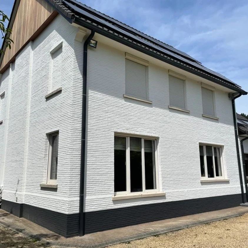 Wit gekaleide woning met zwarte plint