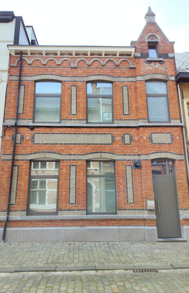 Gerenoveerde gevel van een herenhuis in rode baksteen