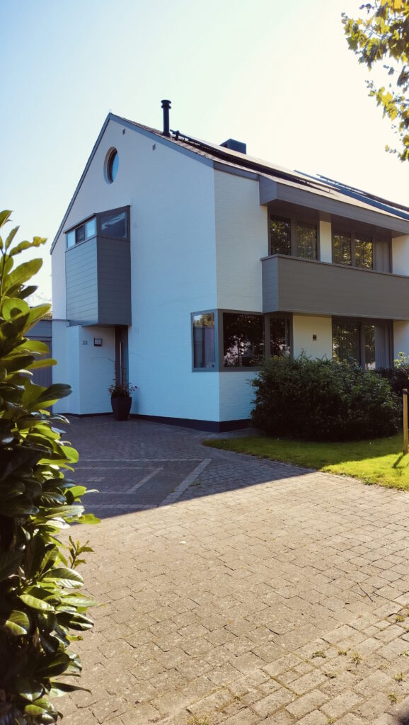 Woning met wit geschilderde gevel na de werken